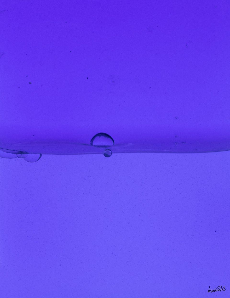 Gotas de agua sobre un fondo azul nacarado.